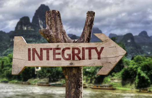 Houten wegwijzer met het woord 'Integrity' voor een landschap met bergen en een rivier
